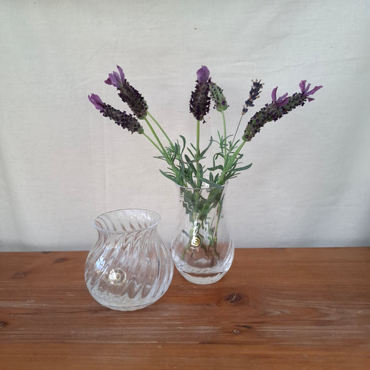 Clear glass vase with lavender flowers on a wooden surface