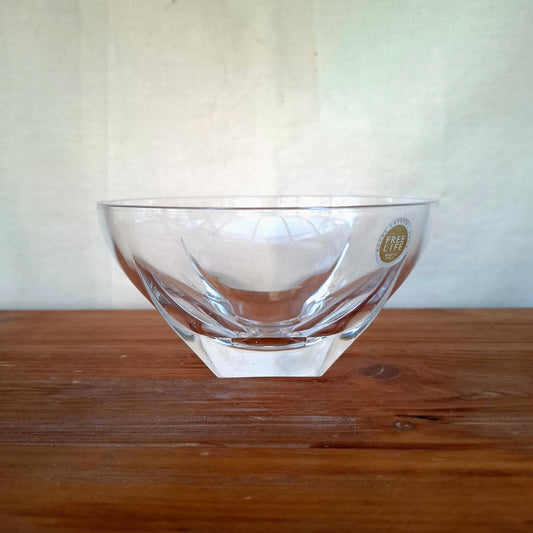 Clear glass bowl with a logo on a wooden surface and white background